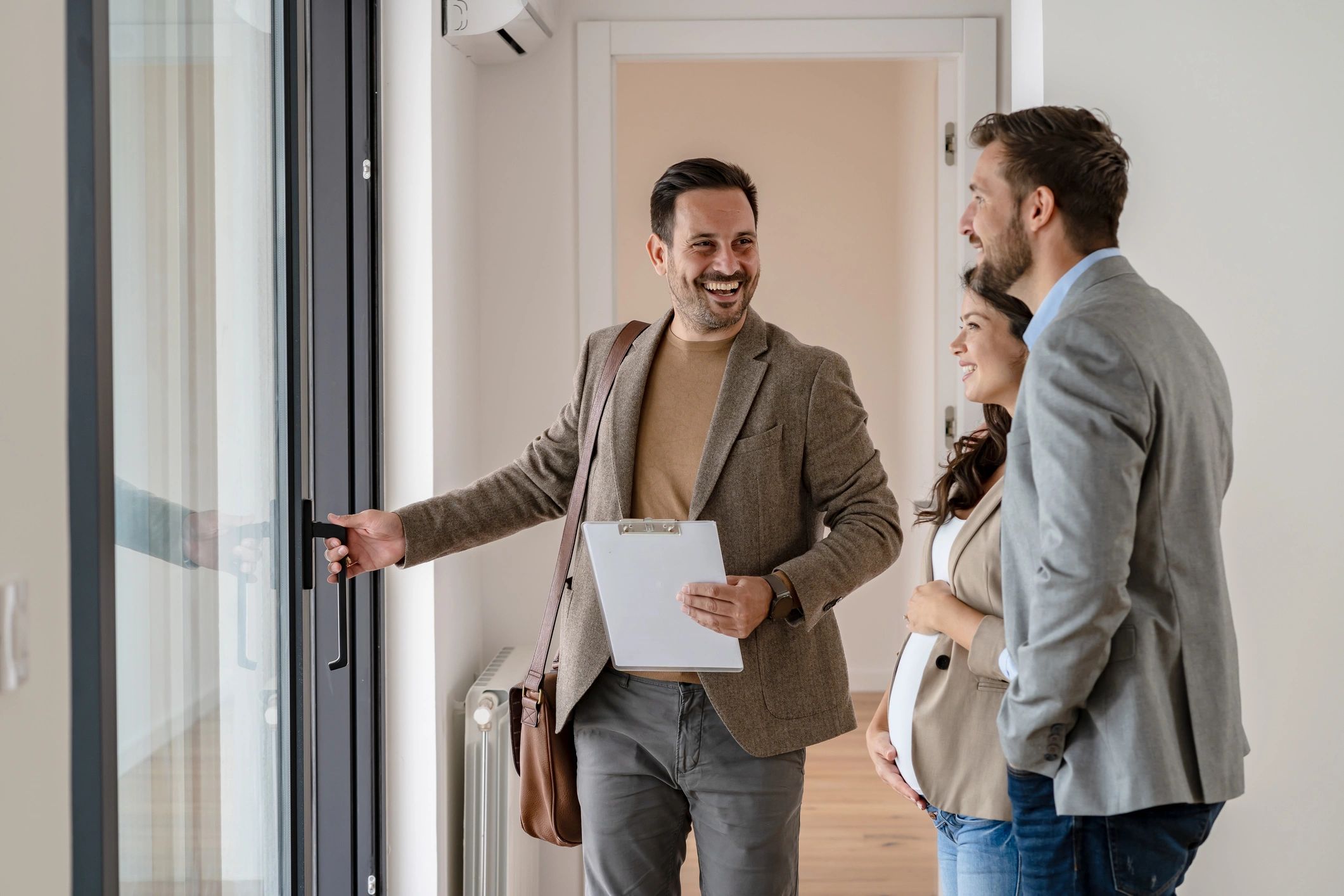 Young married couple talking with a real-estate agent