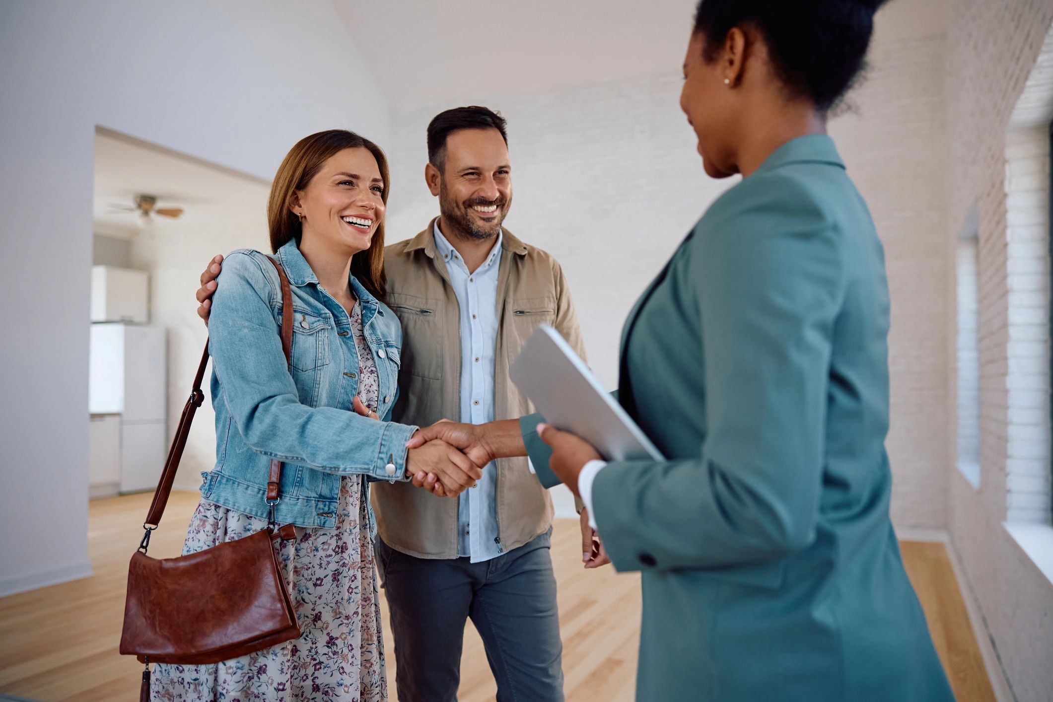Happy woman shaking hands with real estate agent